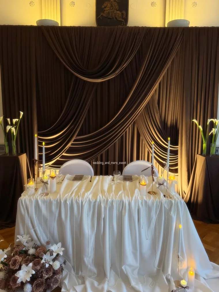 Festlich gedeckte Hochzeitstafel mit Draperie und Goldakzenten